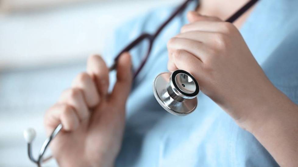 Nurse grabbing stethoscope hanging off shoulders